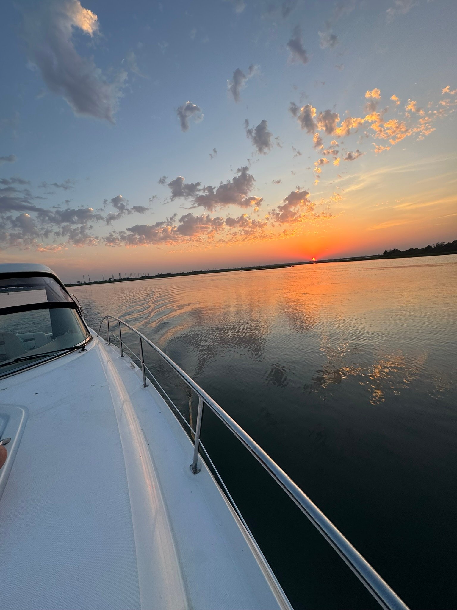 Yacht bow at sunset with water reflection